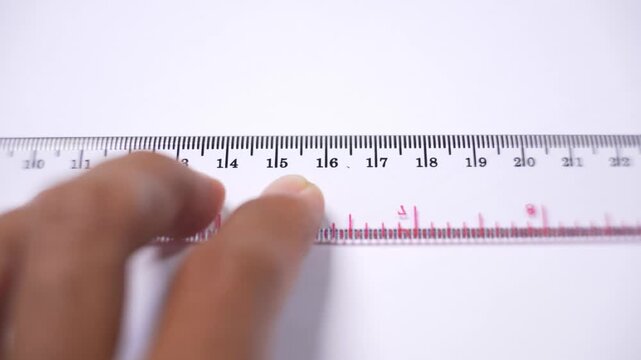 Person using a ruler to draw straight lines on a blank surface