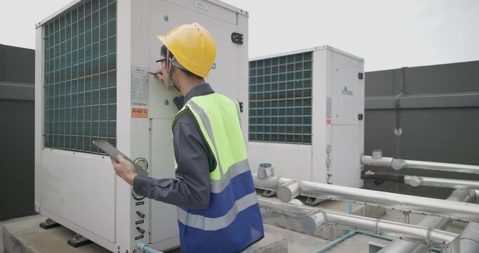 HVAC technician performs maintenance on industrial HVAC equipment in urban setting. Technical expertise and safety measures involved in upkeep of heating, ventilation, and air conditioning systems.
