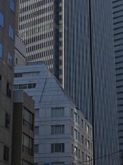 Obraz premium 都会にそびえ立つ高層ビル群の幾何学的な重なりとモダンな建築デザイン