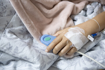 Fototapeta premium Patient hand hospital bed IV drip medical bandage emergency button recovery healthcare illness comfort resting and healing are depicted in this image conveying sense of vulnerability and hope