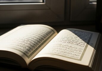 Obraz premium Sunlight illuminates the sacred Arabic text inside the open Holy Quran, suggesting prayer and quiet devotion.