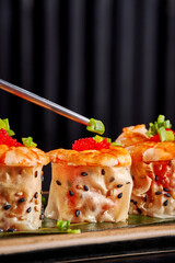 Chef's Hands Decorating Spring Roll with Edible Flowers and Microgreens.