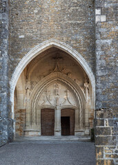 Fototapeta premium Entrance door to a Catholic church in the medieval town of Puy l'Évêque in France