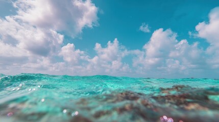 Obraz premium Clear water and white clouds over ocean waves in bright afternoon sky