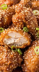 Crispy glazed poultry pieces coated in sesame seeds and garnished with sliced green onions