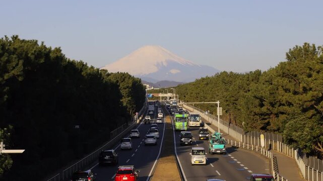 Slow motion of heavy traffic on Route 134 with Mount Fuji at sunrise in Chigasaki, Japan. 4K 60p conform to 50% speed. （日本の茅ヶ崎で、日の出の時間帯に国道134号を走る激しい交通量と富士山のスローモーション。4K 60pを50%に落とした高画質動画）