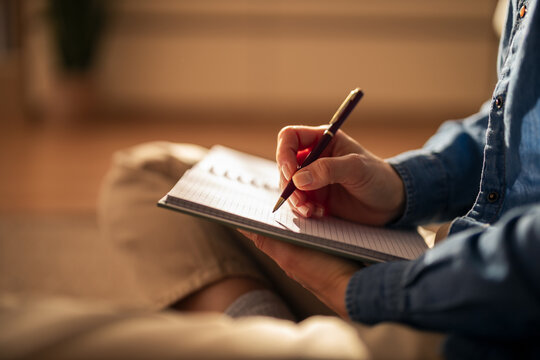 Person writing in notebook for journaling