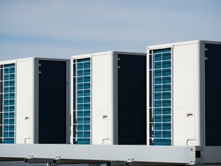 Fototapeta premium Air conditioning units on a rooftop on a sunny day with a blue sky