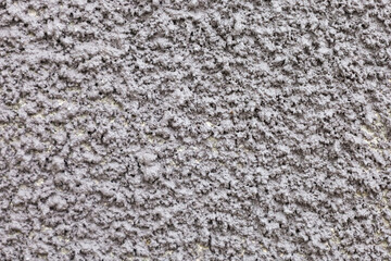 Texture of rough gray surface with intricate patterns reflecting light and shadow in a serene indoor setting