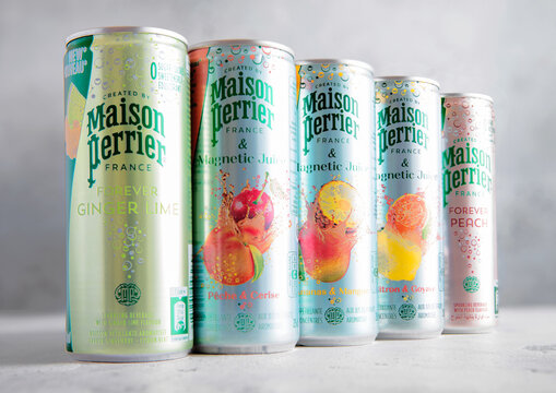 LONDON,UK - AUGUST 09, 2025: Aluminium cans of Perrier carbonated mineral water with various fruit flavors on table background.
