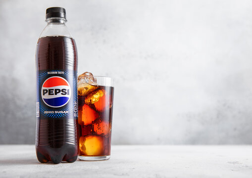 LONDON,UK - AUGUST 05, 2025: Bottle of Pepsi Cola Zero Sugar soda soft drink with glass with ice cubes on light table background.
