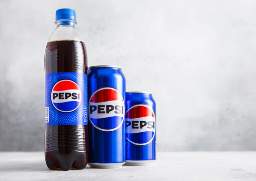 LONDON,UK - AUGUST 15, 2025: Bottle and aluminum cans of Original Pepsi cola soft soda drink on light table background.