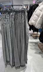 Jeans are hanging on hangers in the store.