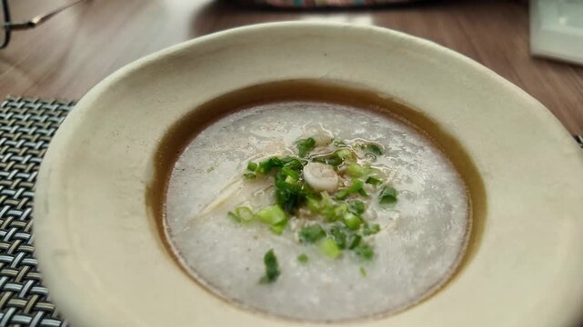 camera shot of rice porridge in bowl on placemat

