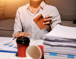 Fototapeta premium Exhausted female employee experiencing burnout while working overtime. A tired professional woman under pressure with a headache.