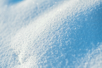 Obraz premium Freshly fallen snow forms a sparkling textured winter background, glistening in bright sunlight with soft shadows and delicate crystalline patterns for a tranquil seasonal scene