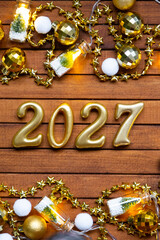 Happy New Year wooden numbers 2027 on cozy festive brown wooden background with sequins, snow,...