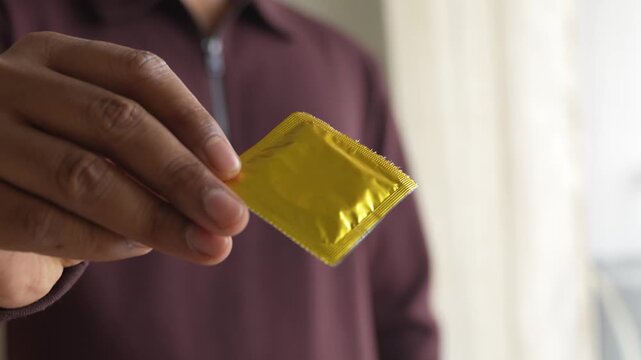 Offering to use pack of condom with fingers.