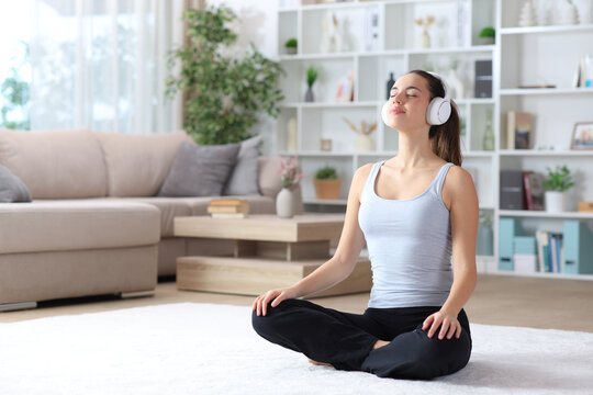 Woman doing yoga guided breathing exercise at home