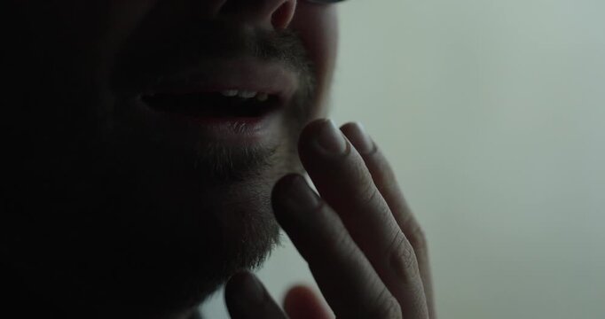 Moody close-up focusing on a man&rsquo;s mouth and beard as he struggles with tears and emotional pain in a dim, cinematic setting. Ideal for themes like grief, vulnerability, depression, heartbreak, and me