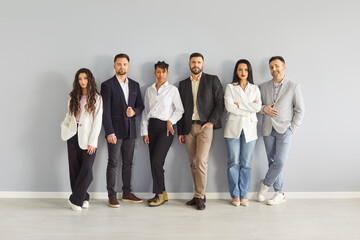 Serious business people group standing by office wall, portrait of confident diverse team. Entrepreneurs and experts posing together. Collaboration of professionals, corporate discipline concept