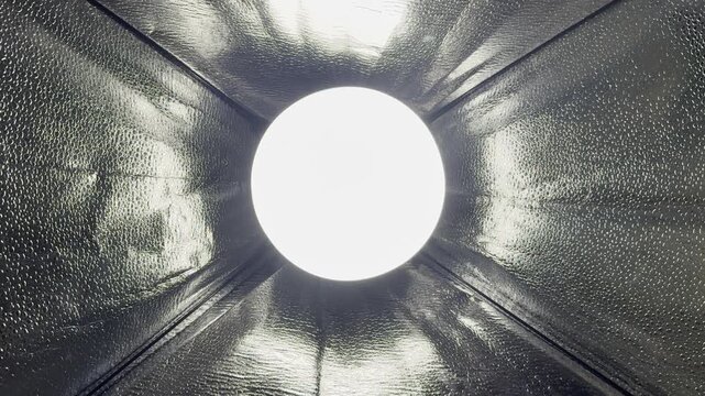 ethereal glowing light piercing textured metallic tunnel depths in futuristic perspective