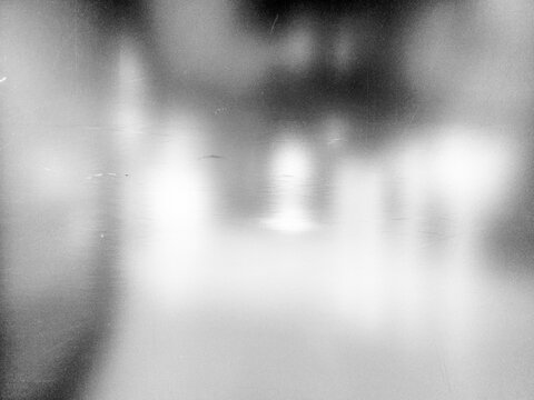 Dirty mirror or glass surface with reflections and a blurry background.