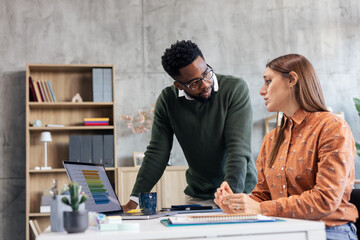 Diverse colleagues analyzing data during office meeting