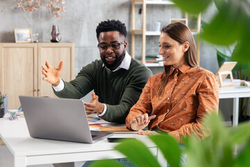 Business colleagues collaborating on a project using laptop