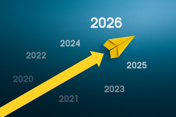Yellow paper plane with arrow up, 2026. Success in business growth concept.