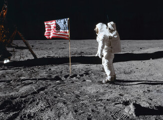 Moon - 20 July 1969: Astronaut on the lunar surface, next to the American flag, during the Apollo 11 mission (Elements of this image furnished by NASA) © TenWit