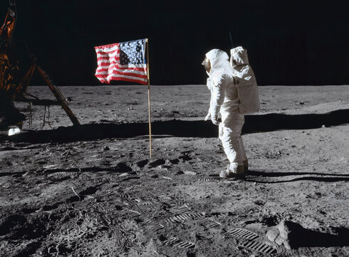 Moon - 20 July 1969: Astronaut on the lunar surface, next to the American flag, during the Apollo 11 mission (Elements of this image furnished by NASA)