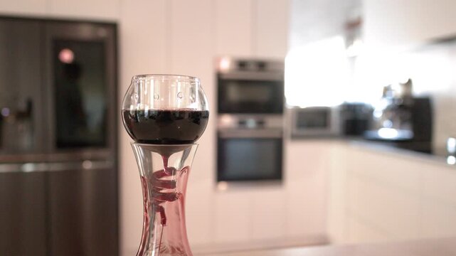 Red Wine Flowing Through a Glass Aerator in a Modern Kitchen