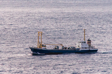 日の出の海。 ぐんじ山展望台から見る美しい伊豆諸島の海。 沖には新島や神津島が見える。 白い石灰岩の崖、白ママ断崖の沖には無人島の早島。 乗用車を乗せた大型貨物船や漁船も見える。 式根島は東京都心から南へ160km。 外周12kmの小さな有人島。 温かい黒潮が当たり水温と水質が高い。 また、リアス式の入り組んだ入り江が多く、海水浴や釣りが盛ん。 温泉島としても有名。海際に多くの無料露天風呂がある。