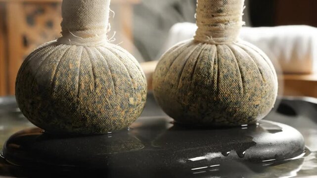 Herbal therapy spa treatment with steam from two medicinal herb poultices for relaxation and wellness