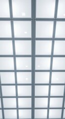 Geometric grid of diffused ceiling lights and window panels creating a clean modern abstract pattern