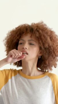 Vertical video: Miming curly woman in raglan singing, dancing and reaching mic at home with friends