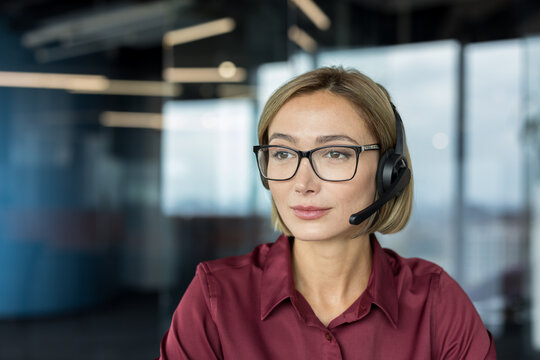 Businesswoman wearing a headset and spectacles in an office environment, providing dedicated customer service, technical support, and online consulting assistance