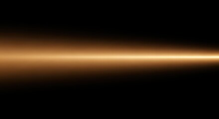 Abstract golden light streak across black background with bokeh effect