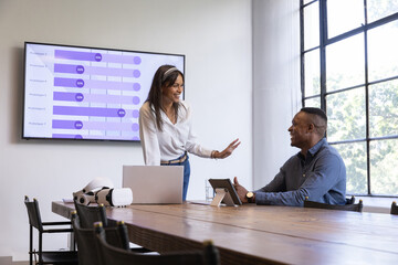 Diverse coworkers gesturing, listening at conference table with vr headset, purple bar chart © wavebreak3