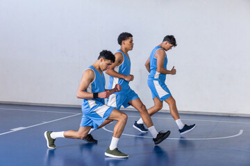 Obraz premium African american teenage basketball teammates performing forward lunges on court in uniforms