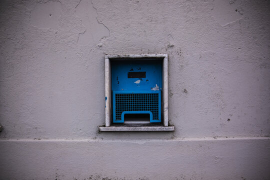 Small barred windows of an old stadium ticket office. A minimalist photograph of a wall with small ticket windows. Retro, minimalist photo