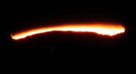 Fiery orange light trail with film grain effect on black background