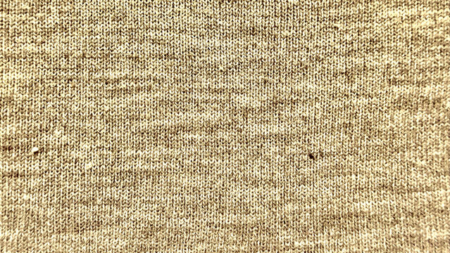 beige knitted wool texture closeup with soft yarn stitches and warm cozy pattern