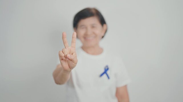 Elderly with dark Blue or Navy blue Ribbon for concept of March Colorectal and Colon Cancer Awareness month, May Arthritis awareness, July Juvenile arthritis and Childhood. Health and world cancer day
