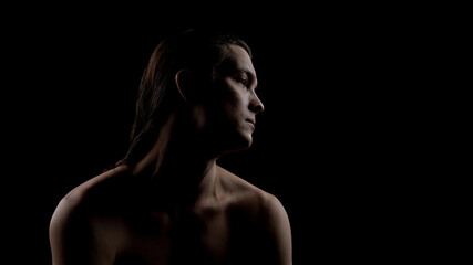 Male profile portrait in shadow highlighting face and neck skin. Concept of men facial skincare, skin protection, daily grooming routine, and confident minimal lifestyle. © Lustre Art Group 