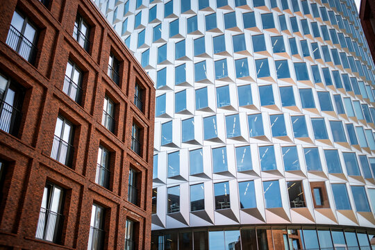 Modern urban architecture facade with brick building contrast beside glass creating a bold pattern of windows and geometry for city development themes