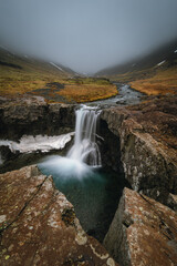 Fototapeta premium Beautiful Skutafoss waterfall flowing near Hofn. Scenic Icelandic nature with a stream falling over rocky terrain in the East Fjords.
