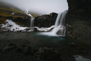Obraz premium Beautiful Skutafoss waterfall flowing near Hofn. Scenic Icelandic nature with a stream falling over rocky terrain in the East Fjords.