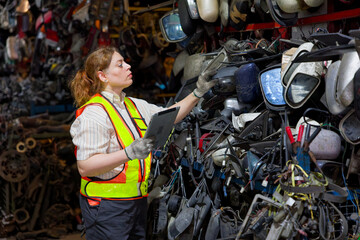 Worker inspecting auto parts in a warehouse setting